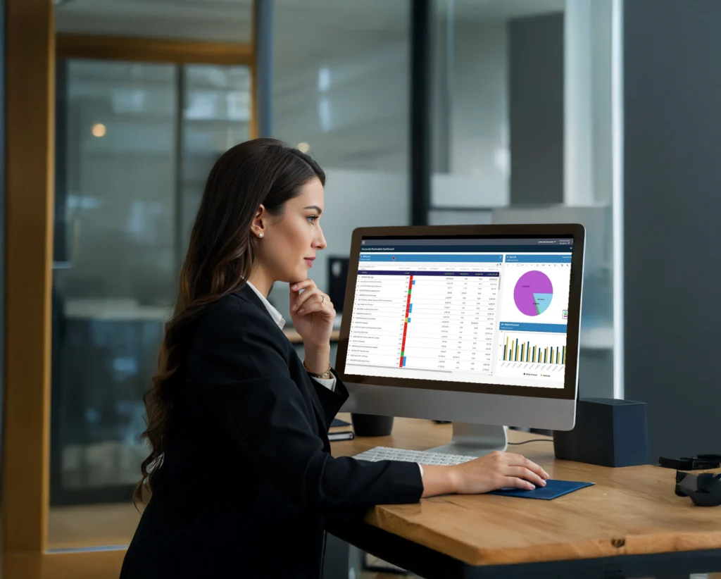A woman in business attire works at a computer displaying accounting software. Text on the image reads: "Making the Most of Deltek: Why Outsourced Accounting is a Smart Strategy for AEC Firms" by Lisa Lee.